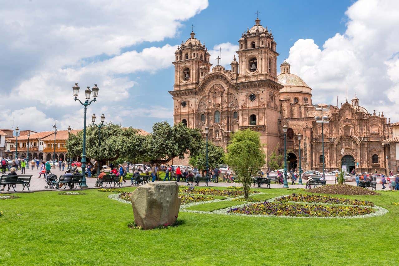 Plaza de Armas repleta de pessoas com destaque para a igreja da Companhia de Jesus ao fundo