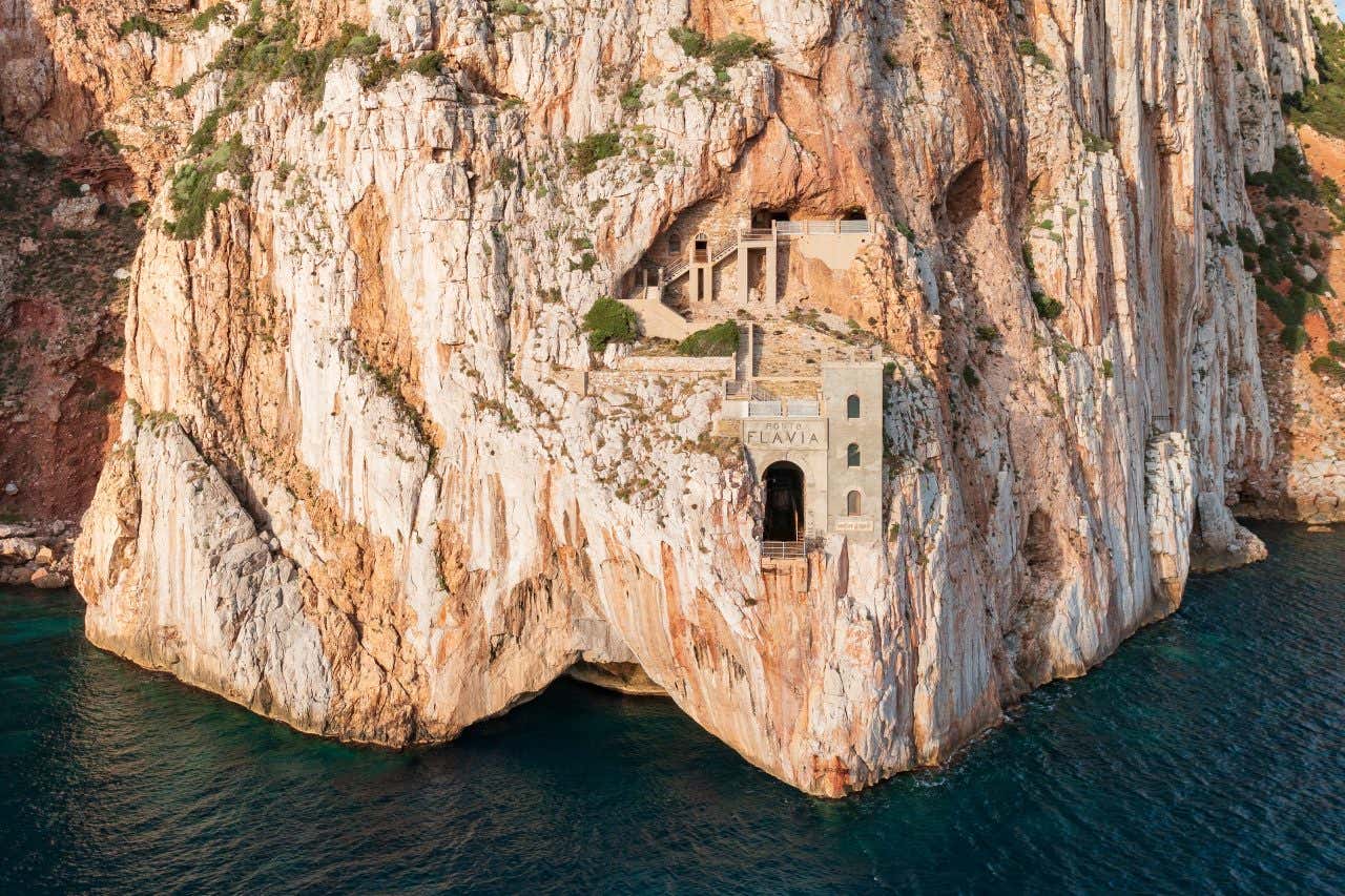 Porto Flavia's mine built into the cliffside overlooking the sea.