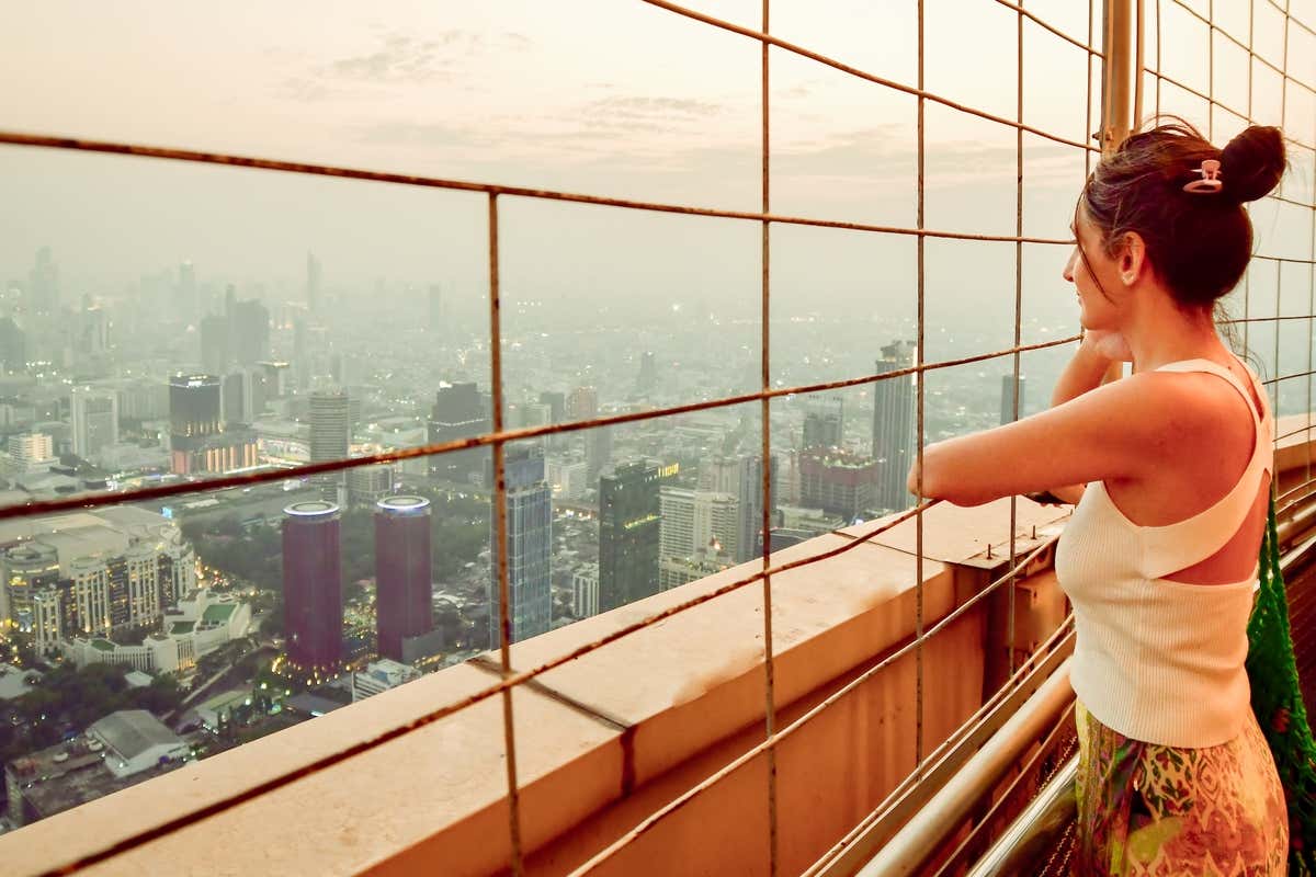 Una mujer mirando el skyline de Bangkok desde Baiyoke Sky Hotel
