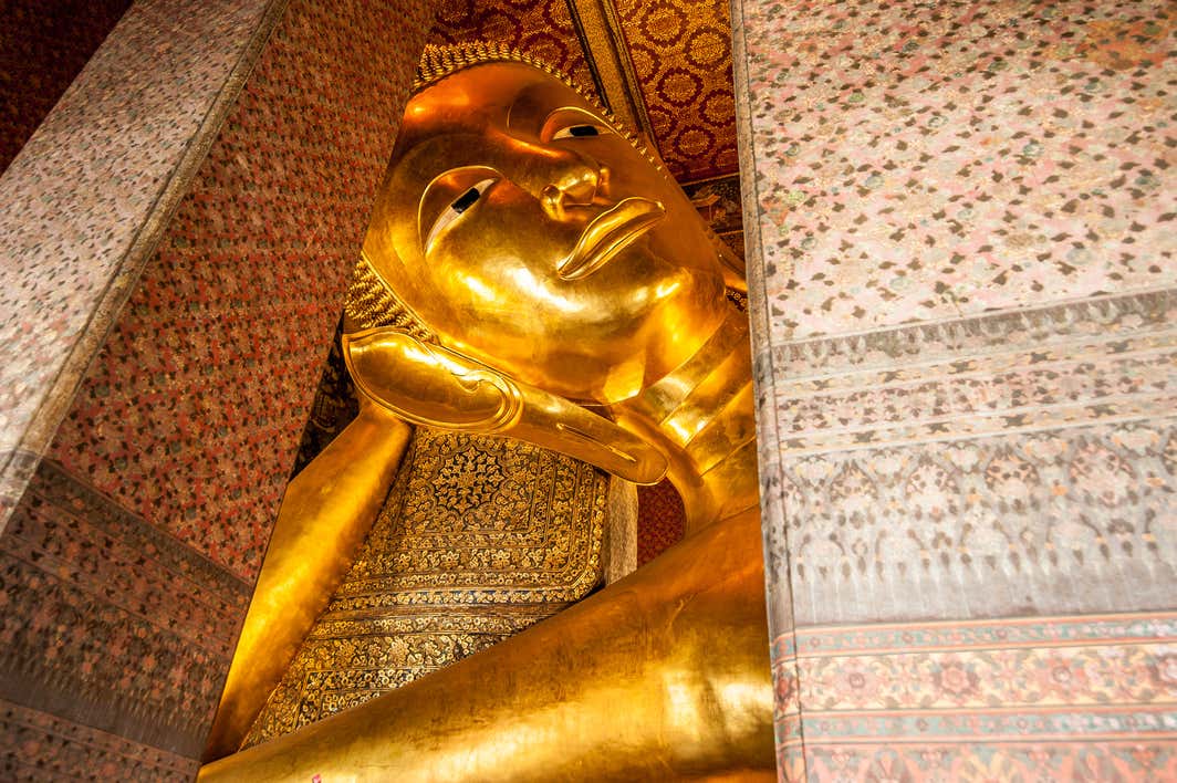 Escultura de un buda enorme reclinado de color oro 