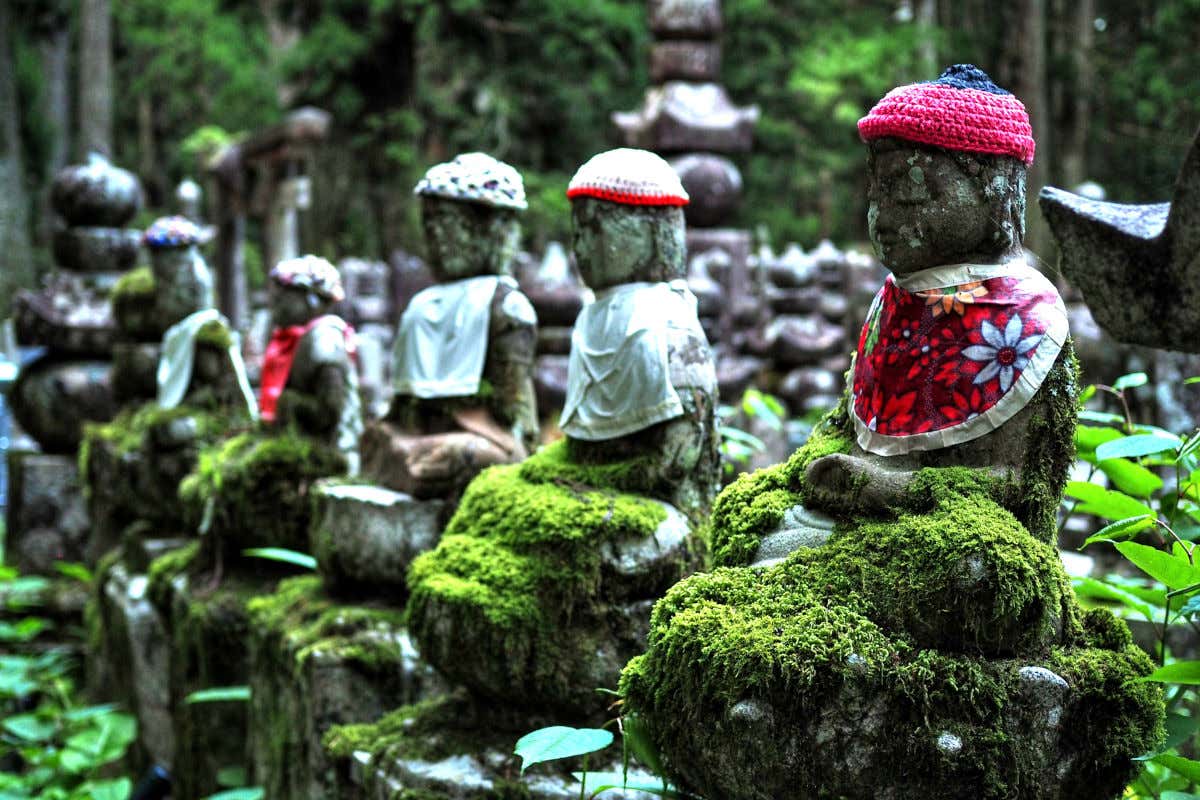 Pequeñas esculturas de piedra repletas de musgo en un cementerio de Japón