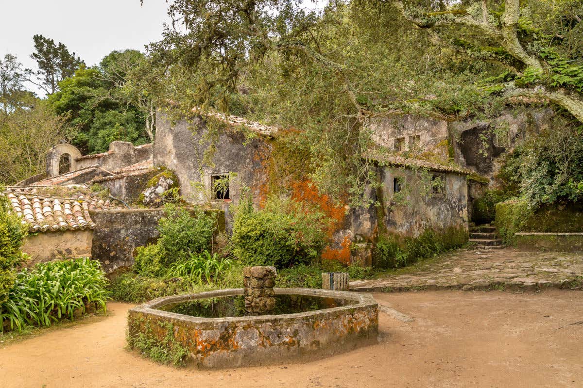 Pequeñas y antiguas edificaciones de piedra de un convento rodeadas de vegetación