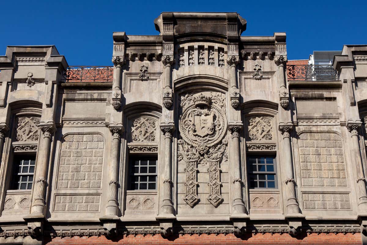 Fachada de un edificio histórico, con un escudo gremial en su parte frontal
