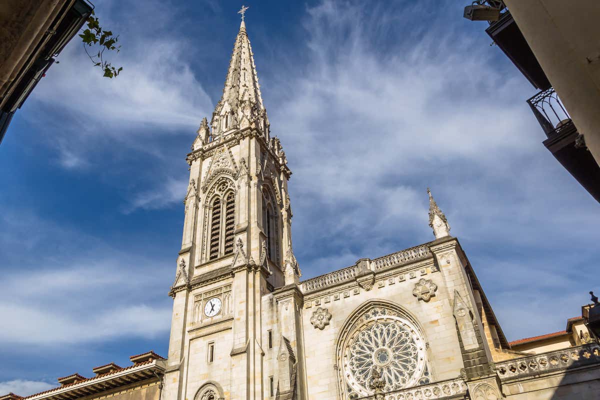 Fachada de una catedral, con el rosetón y su campanario de estilo neogótico en primer plano