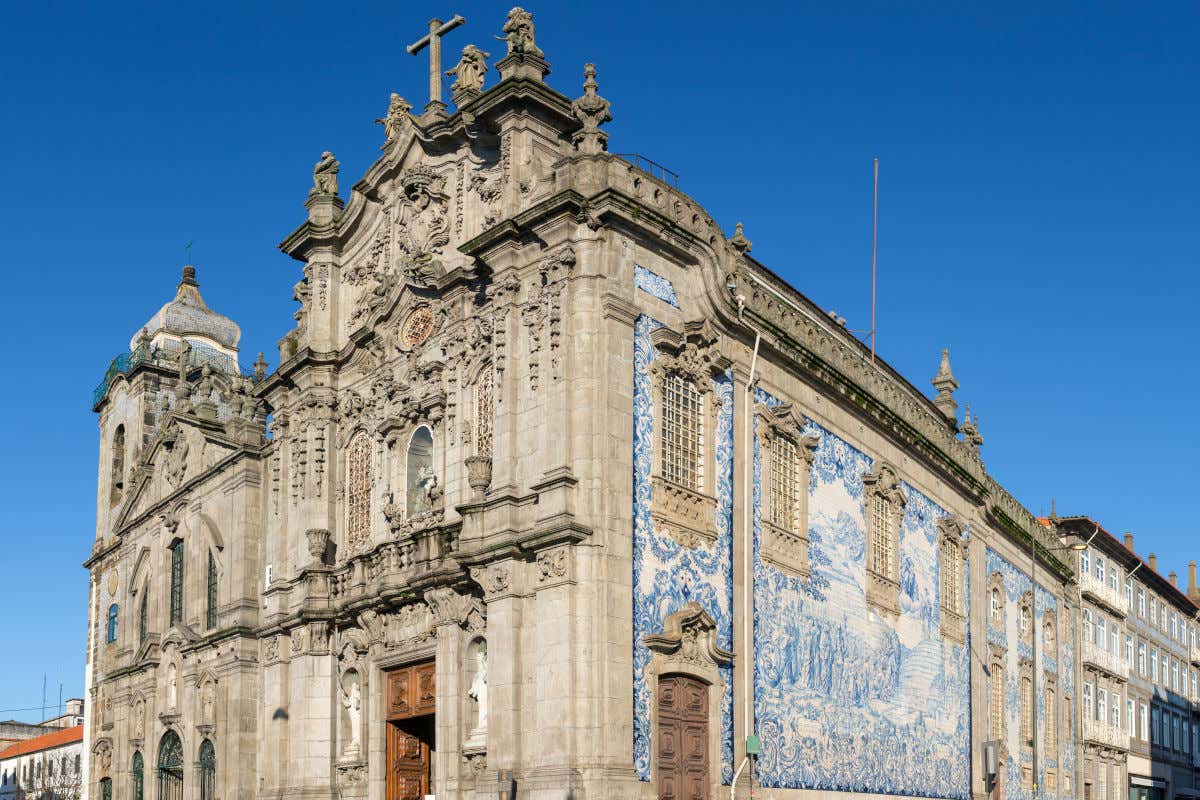Dos iglesias anexas con una fachada de sobrecargada decoración y un lateral repleto de azulejos blancos y azules