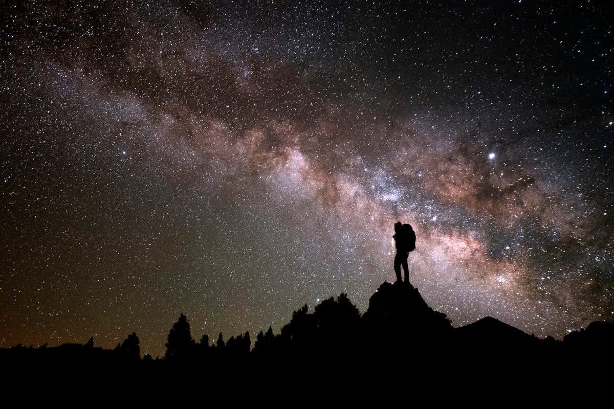 Una personas contempla el cielo nocturno repleto de estrellas en el Roque de los Muchachos, una de las actividades que hacer en La Palma