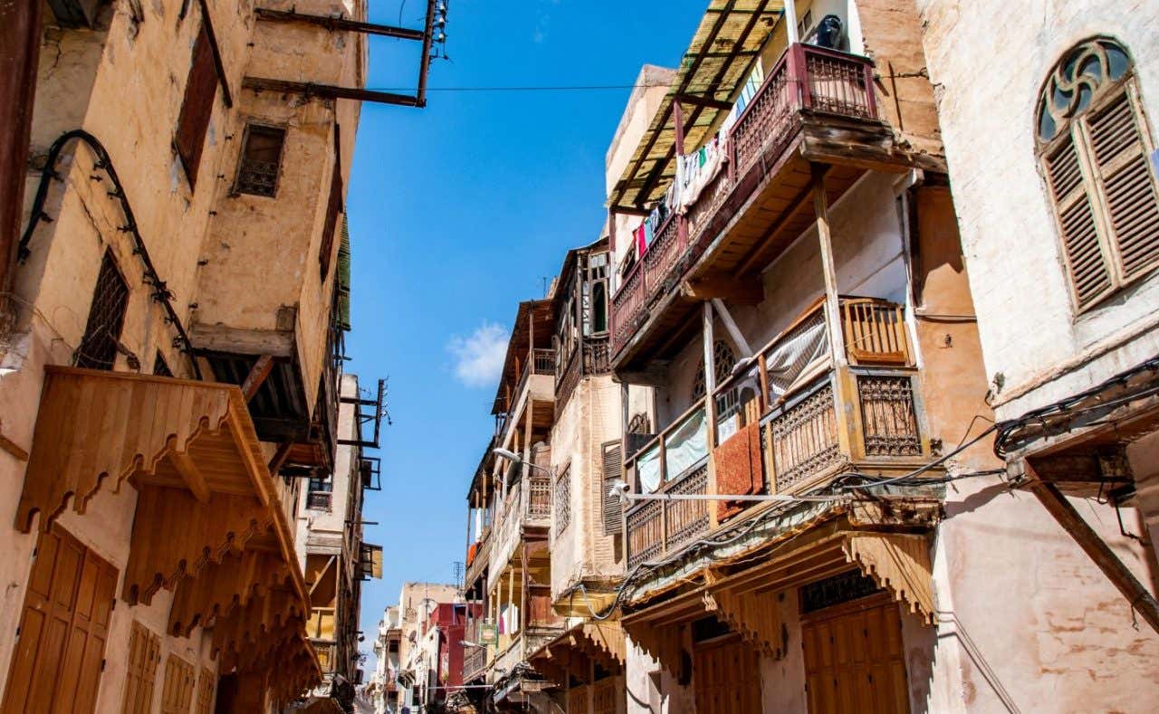 Unos balcones antiguos sobresalen de edificios históricos en un callejón
