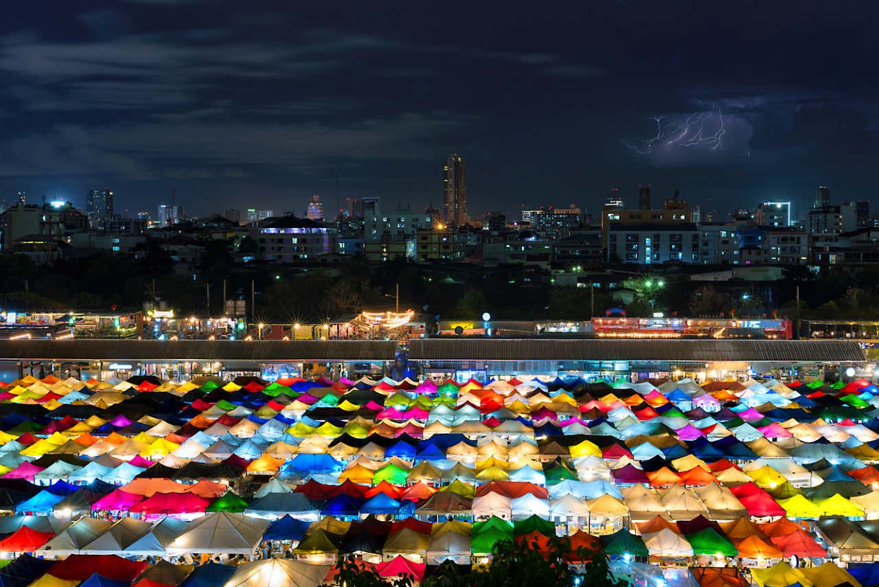 Vistas del mercado Chatuchak de noche con los puestos de colores iluminados