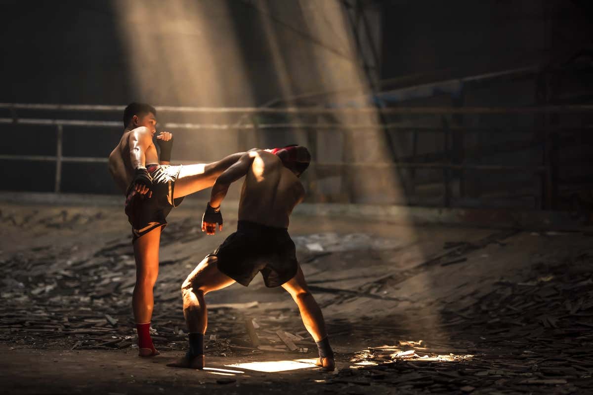 Dos personas en un ring haciendo Muay Thai, el deporte nacional de Tailandia