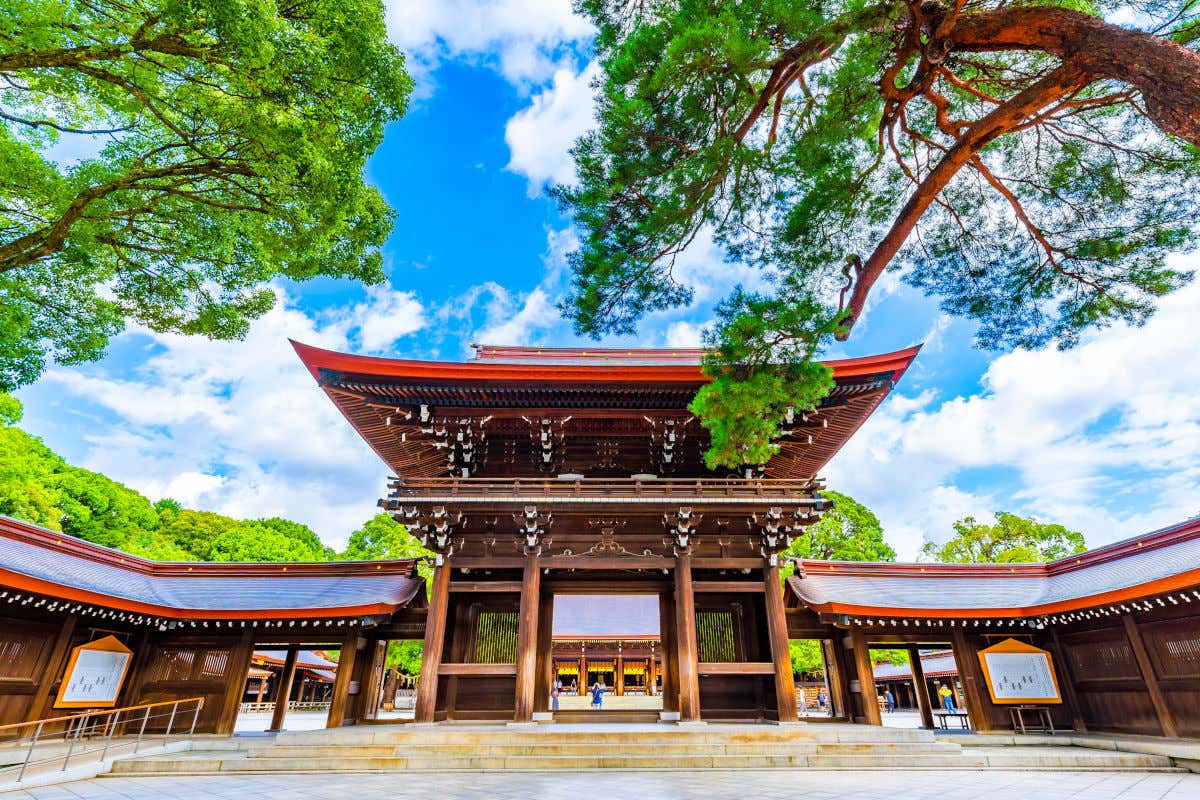 Un santuario japonés con un gran patio central rodeado de árboles en un día parcialmente nublado