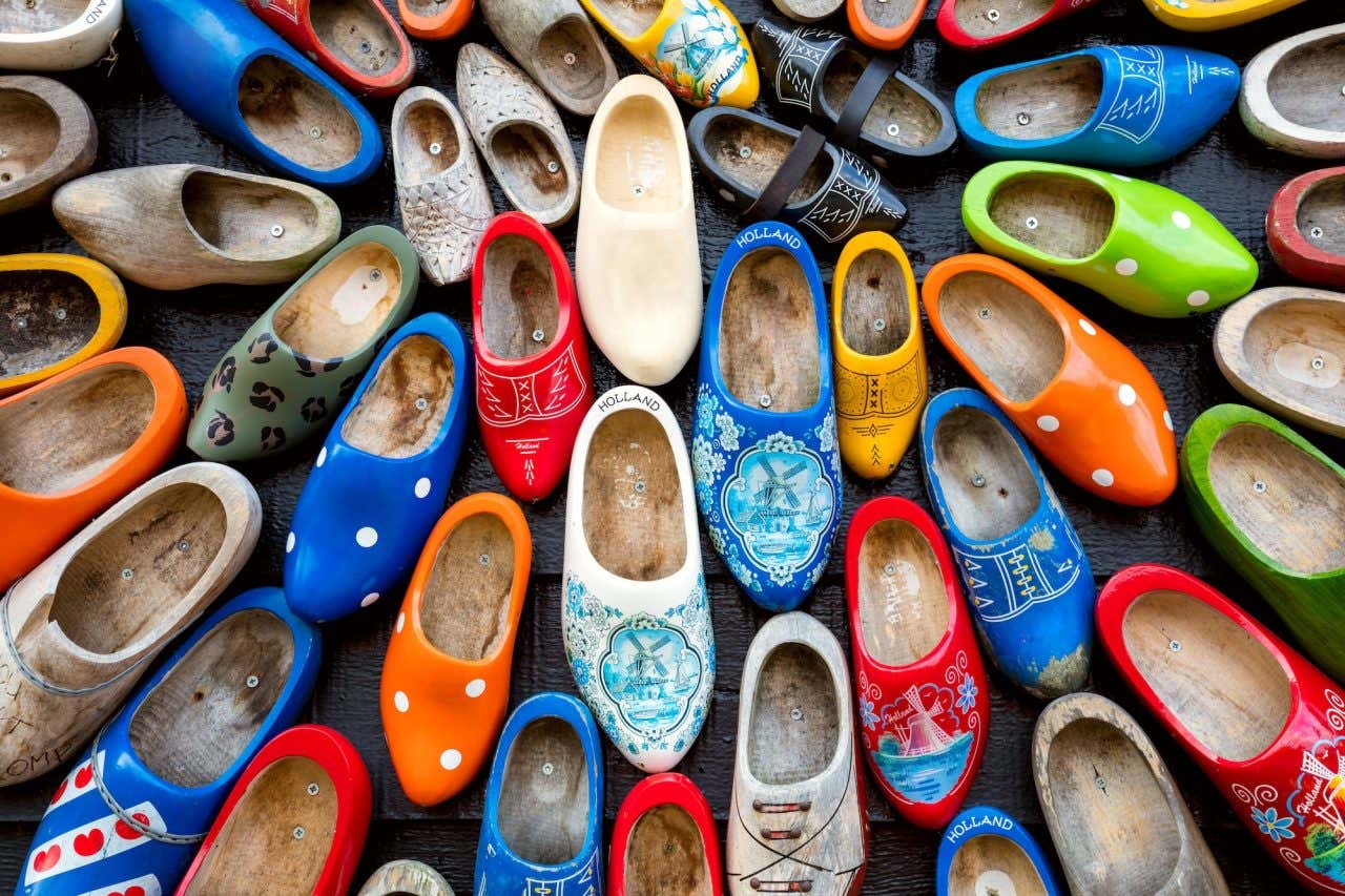 Muitos klomps antigos coloridos contra o fundo de uma parede de madeira