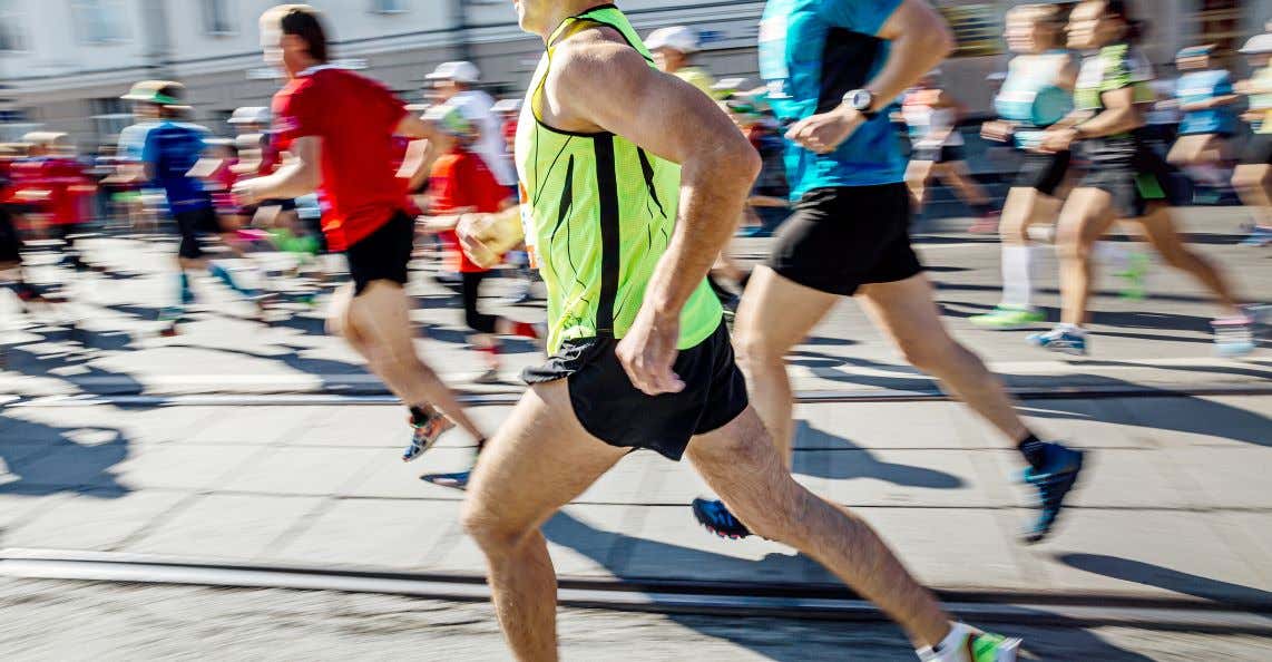A view of people running a road marathon, one person in clear sight and people blurry behind them