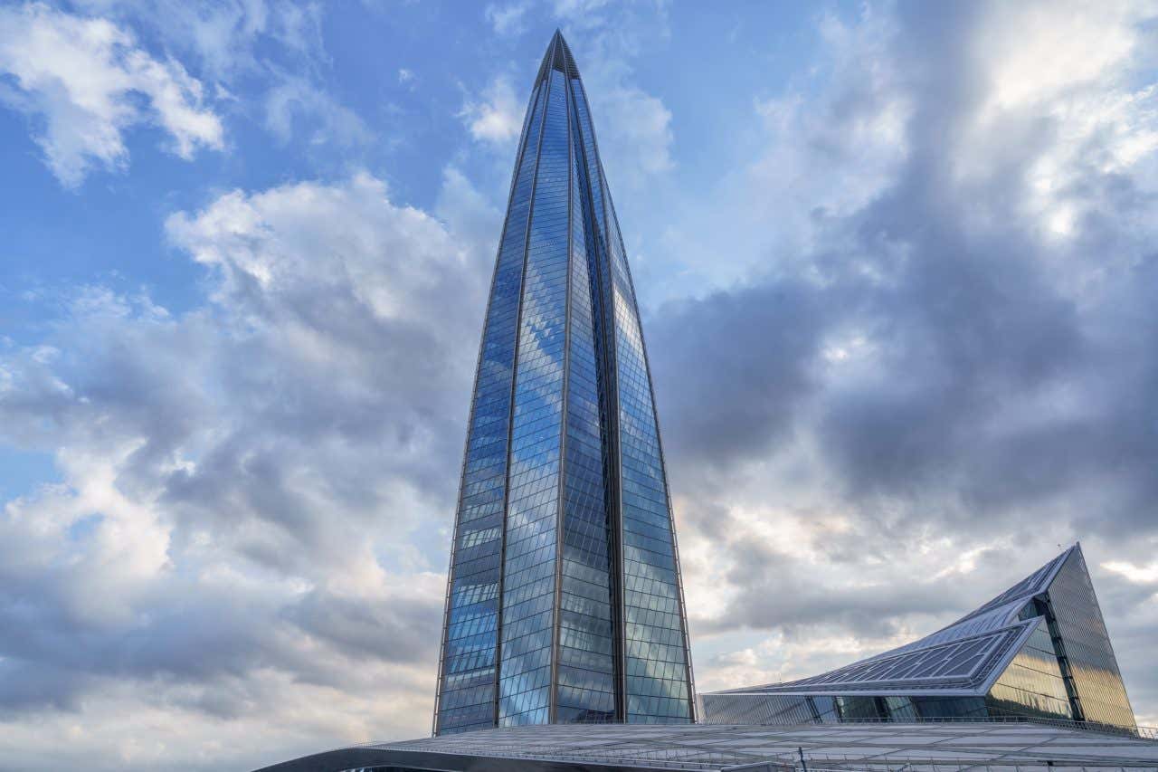 Lakhta Centre in St. Petersberg, Russia as seen from its base with a cloudy sky in the background.
