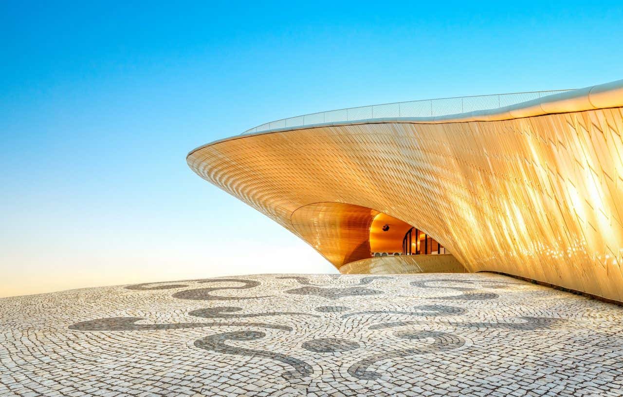 Fachada futurista refletindo o dourado do sol em um dia ensolarado em Lisboa