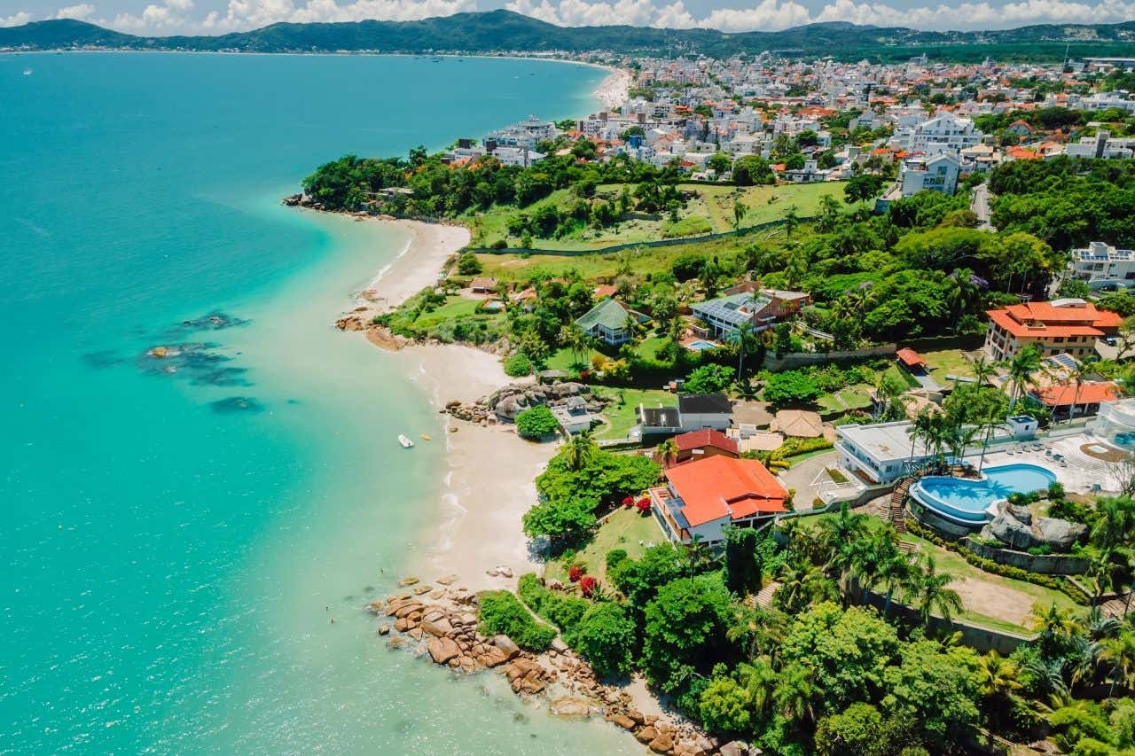 Vista aérea de uma praia com mar azul-turquesa em Florianópolis