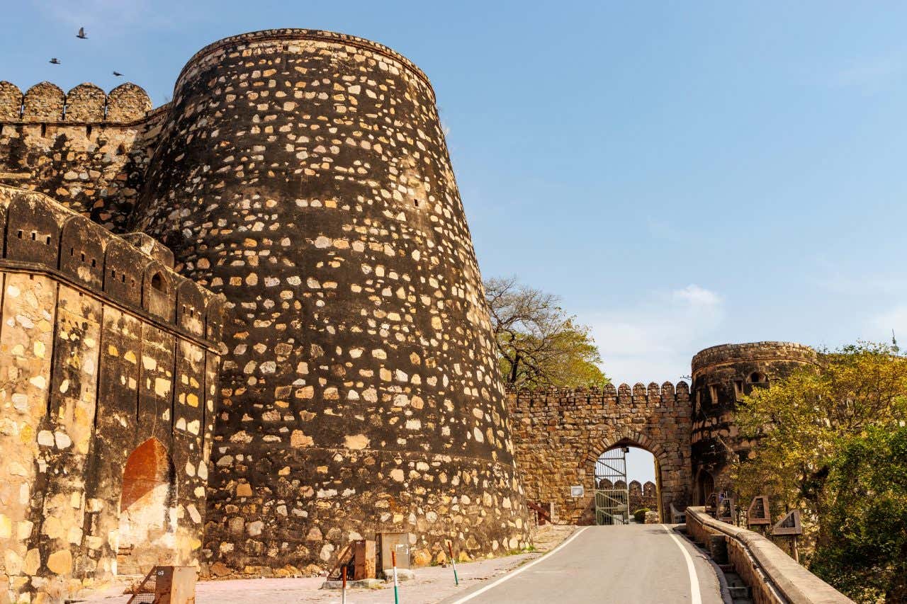 A street in Jhansi, with an old structure on the left and a gate at the end of the road.