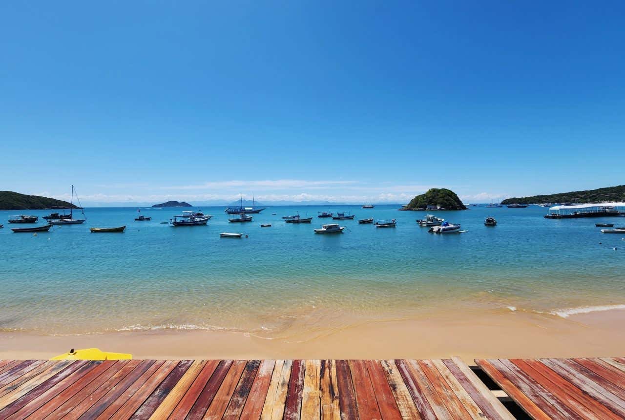 Vista do píer da praia dos Ossos com vários barcos na água
