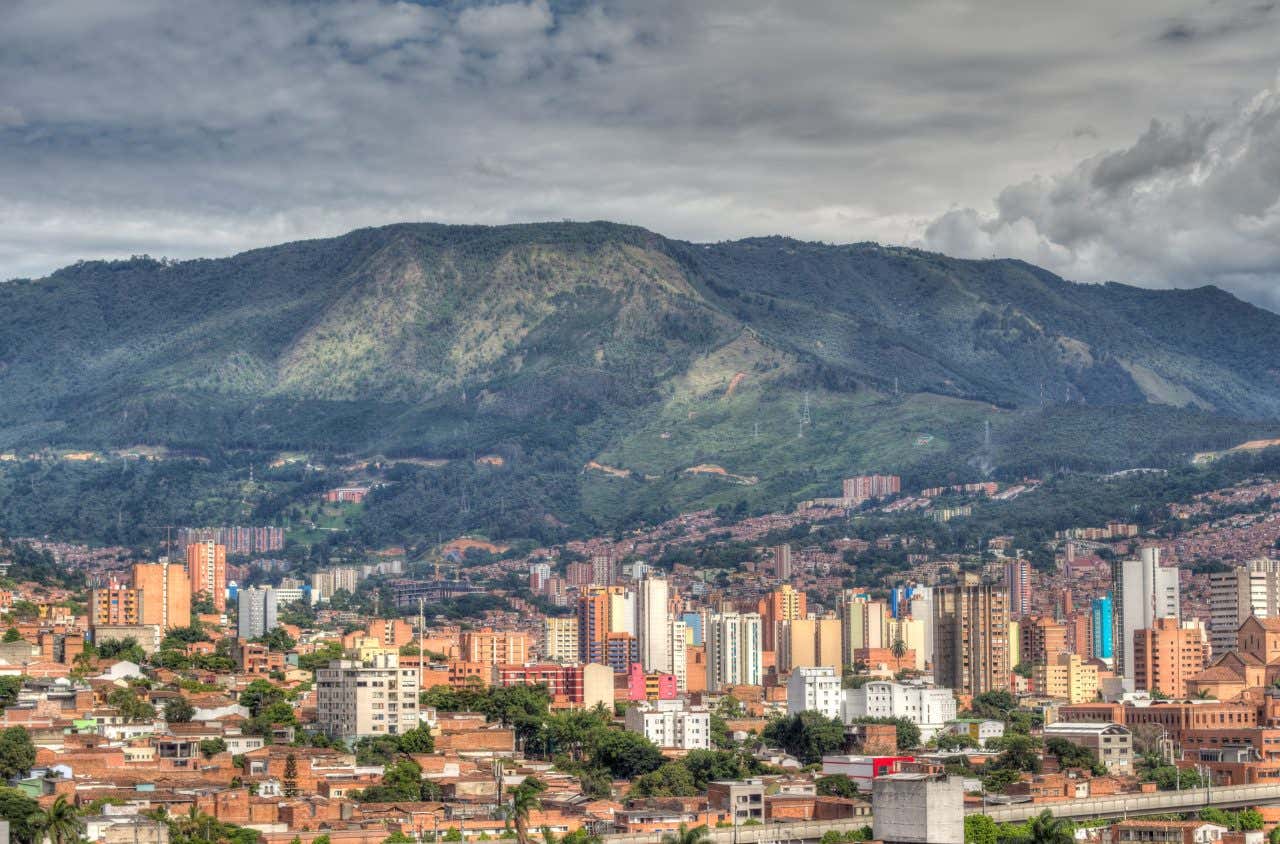 Medellín, à faire en Colombie, ses gratte-ciel et montagne en arrière-plan, ciel nuageux