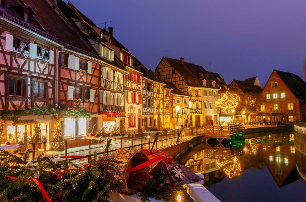 Scorcio su un canale di Colmar in una sera invernale, illuminata dalle luminarie a tema natalizio appese sulle facciate delle antiche case a traliccio della città francese