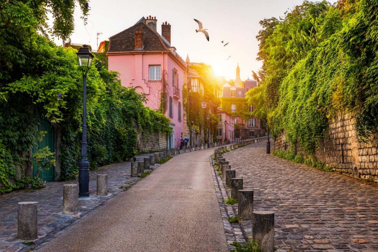 Una callejuela empedrada y empinada en París durante un atardecer