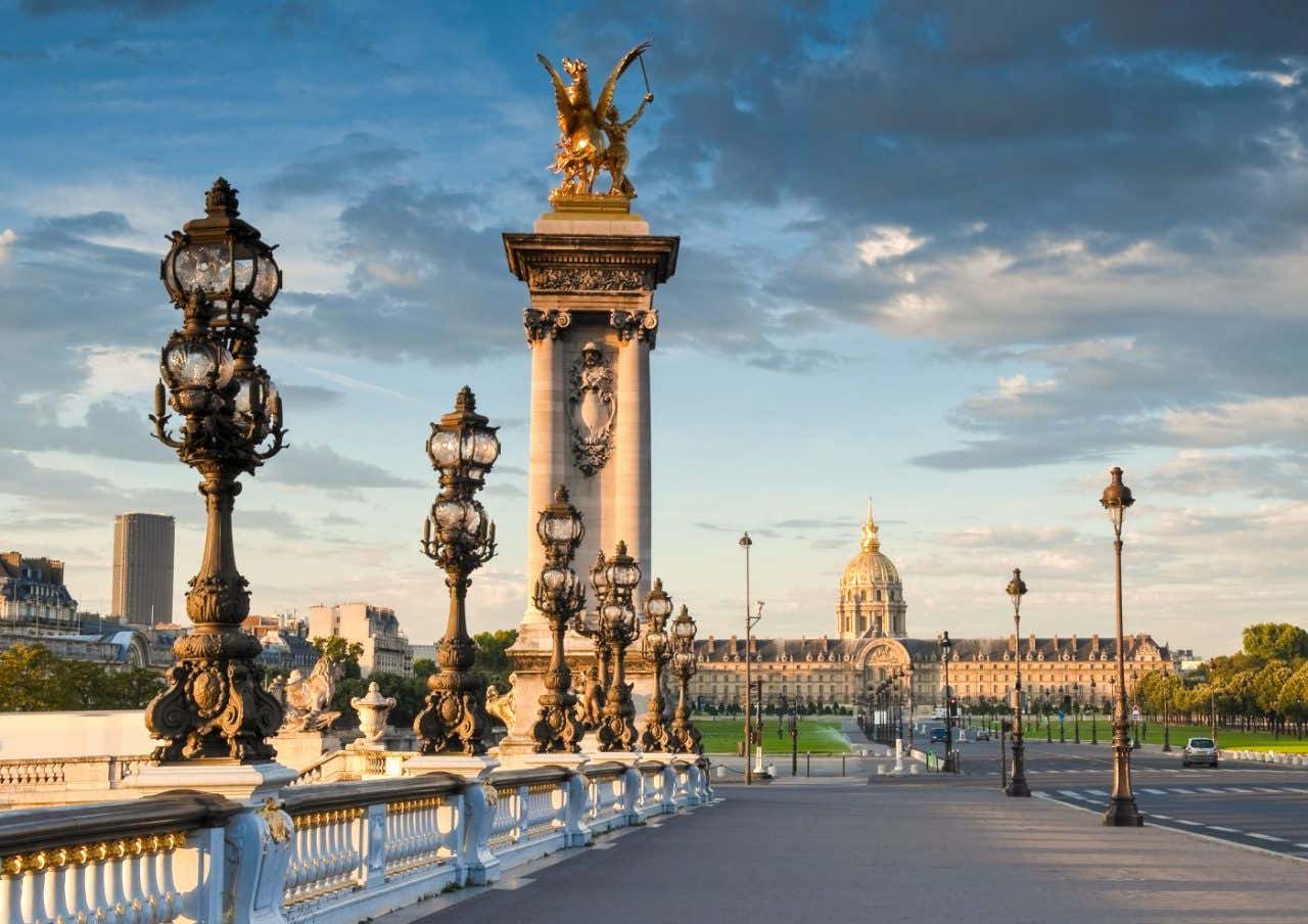 Un puente monumental con un edificio histórico al fondo