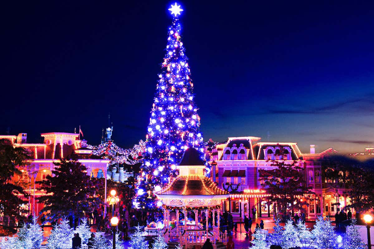 Abeto navideño iluminado por la noche del parque Disneyland® Paris