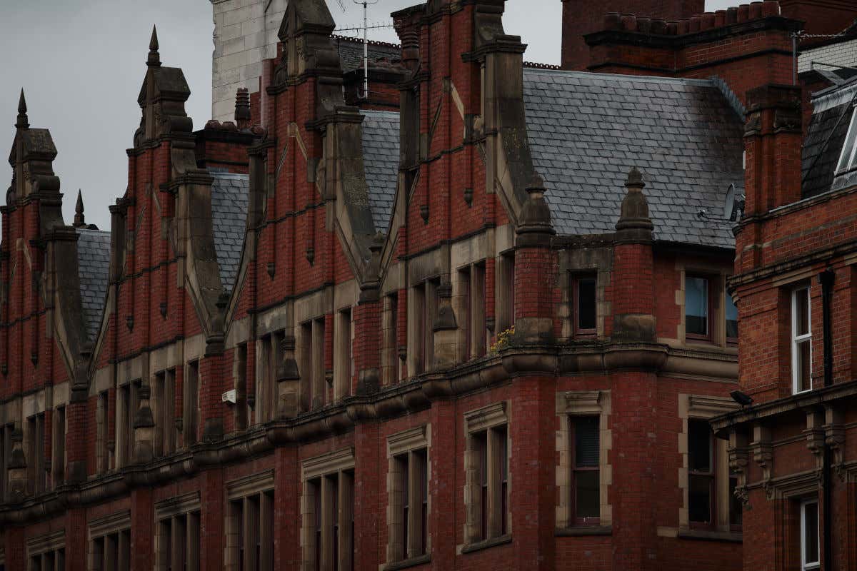 Varios edificios gemelos hechos de ladrillo y con dejados de pizarra negra en un día bastante nublado