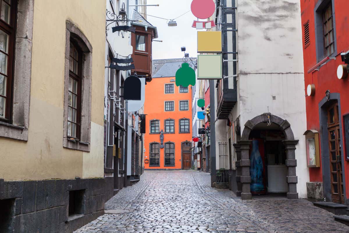 Una calle adoquinada con casas de estética medieval en el centro histórico de Colonia en un día con muchas nubes