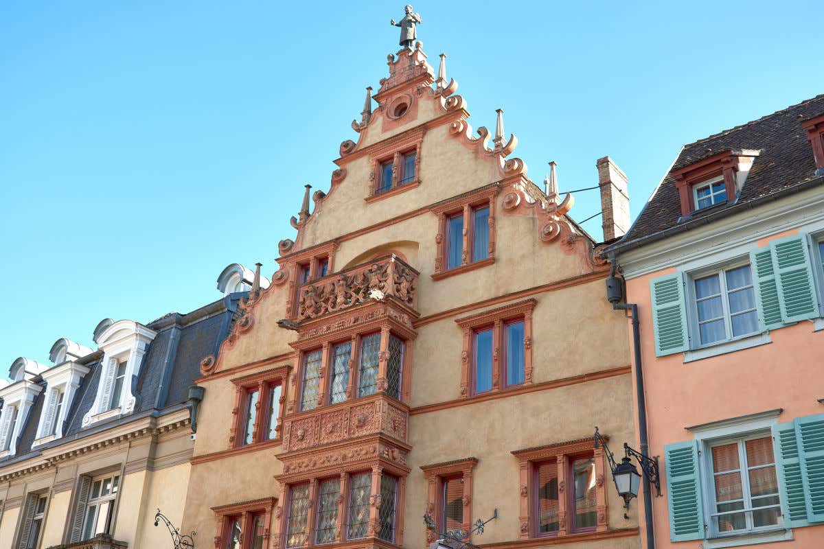 Una casa de varias alturas con un balcón decorado con viderieras y diferentes esculturas