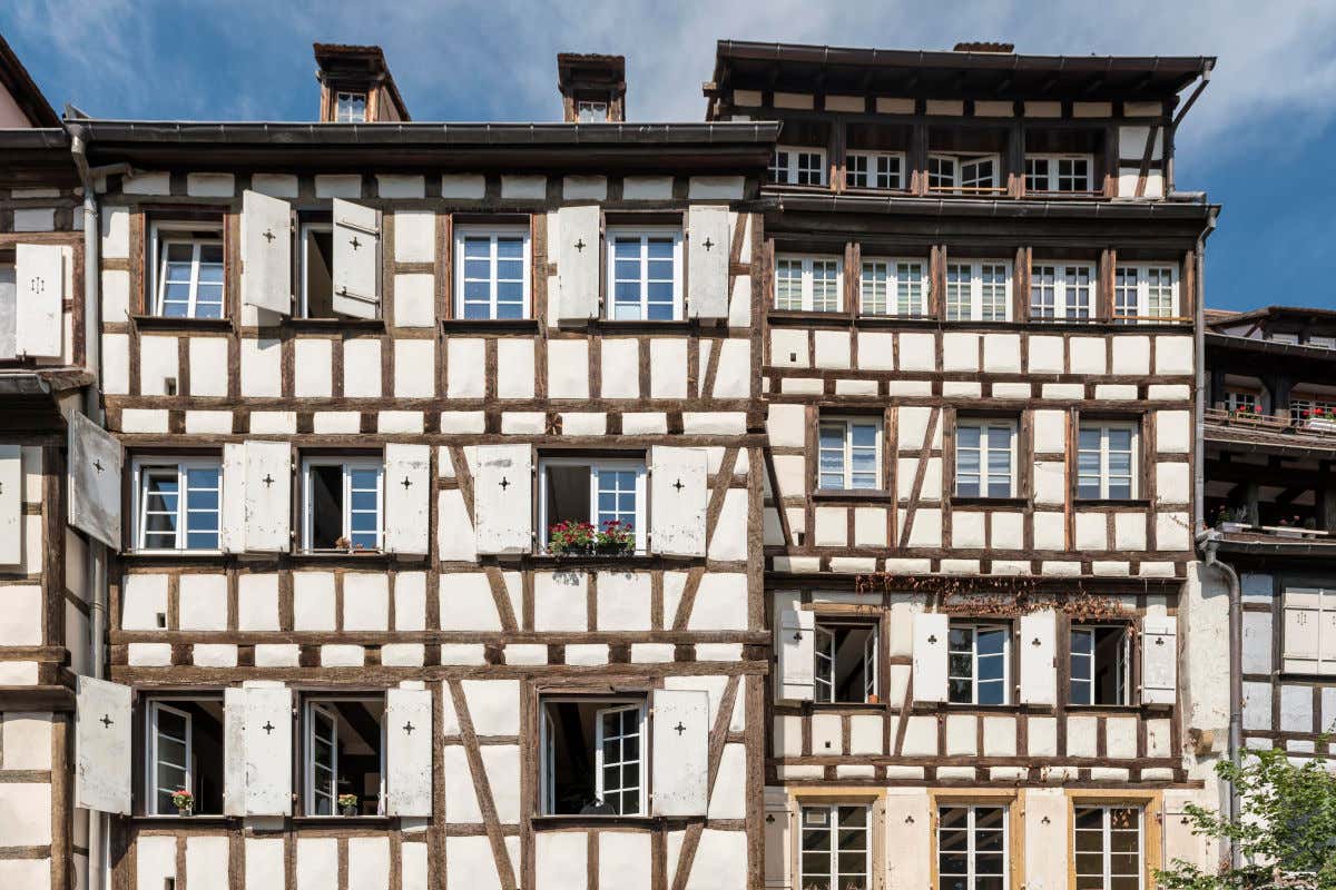 Dos casas anexas de unos tres pisos de alturas y con una fachada blanca con vigas de madera descubiertas