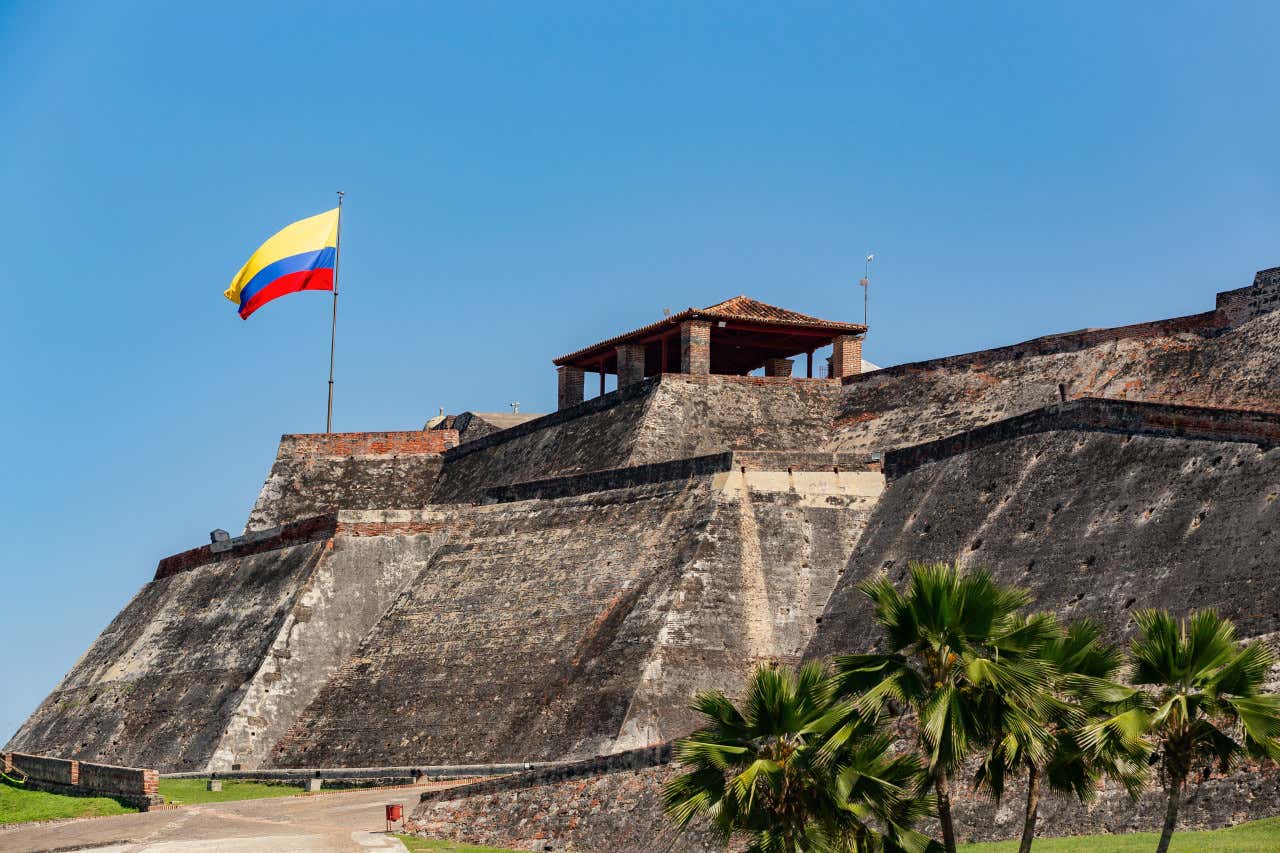 Una bandera de Colombia ondea en la cima del castillo San Felipe de Barajas, en Cartagena de Indias
