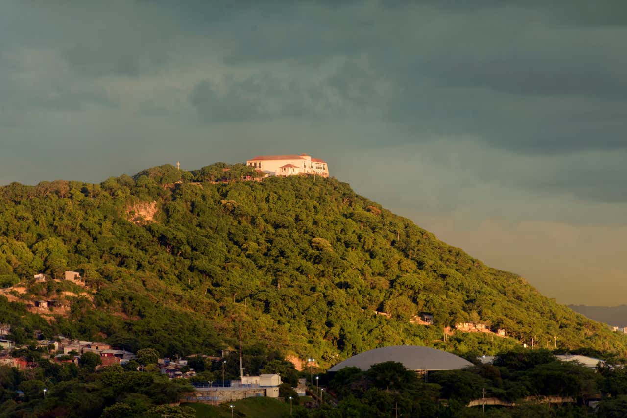 Cerro de la Popa, en Cartagena de Indias, con una casa en su cima, un día nublado al atardecer