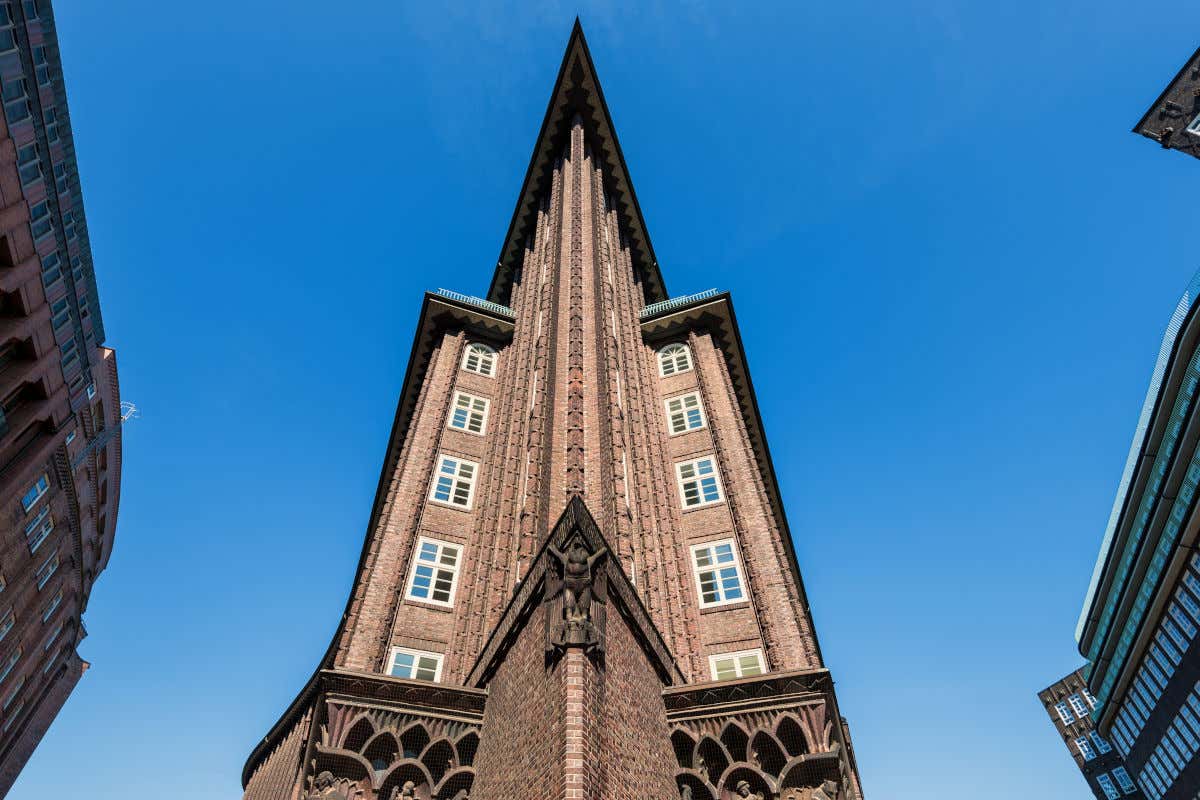 Un edificio de ladrillo de gran altura y decorado con una escultura