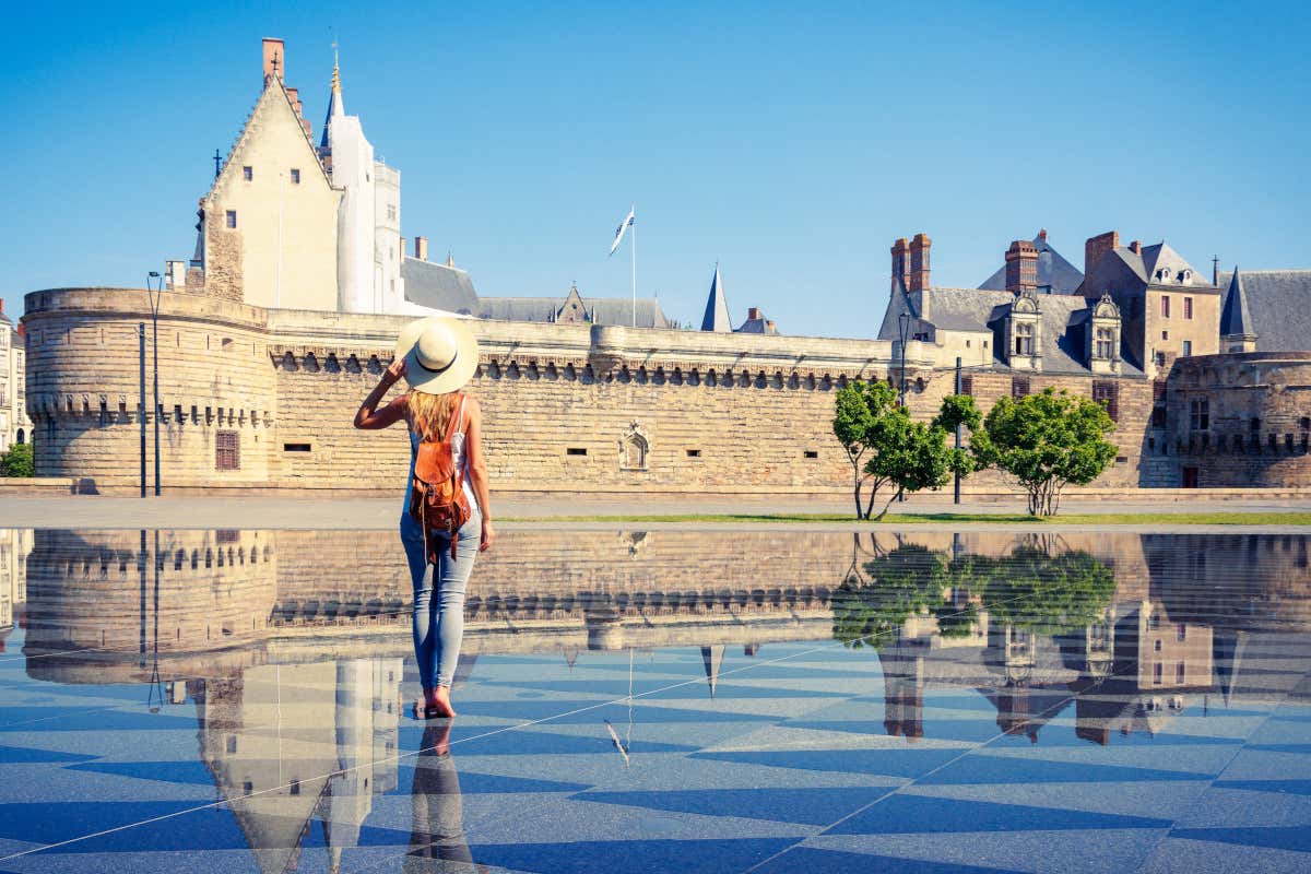 Una mujer contemplando en Nantes la fortaleza de los duques de Bretaña