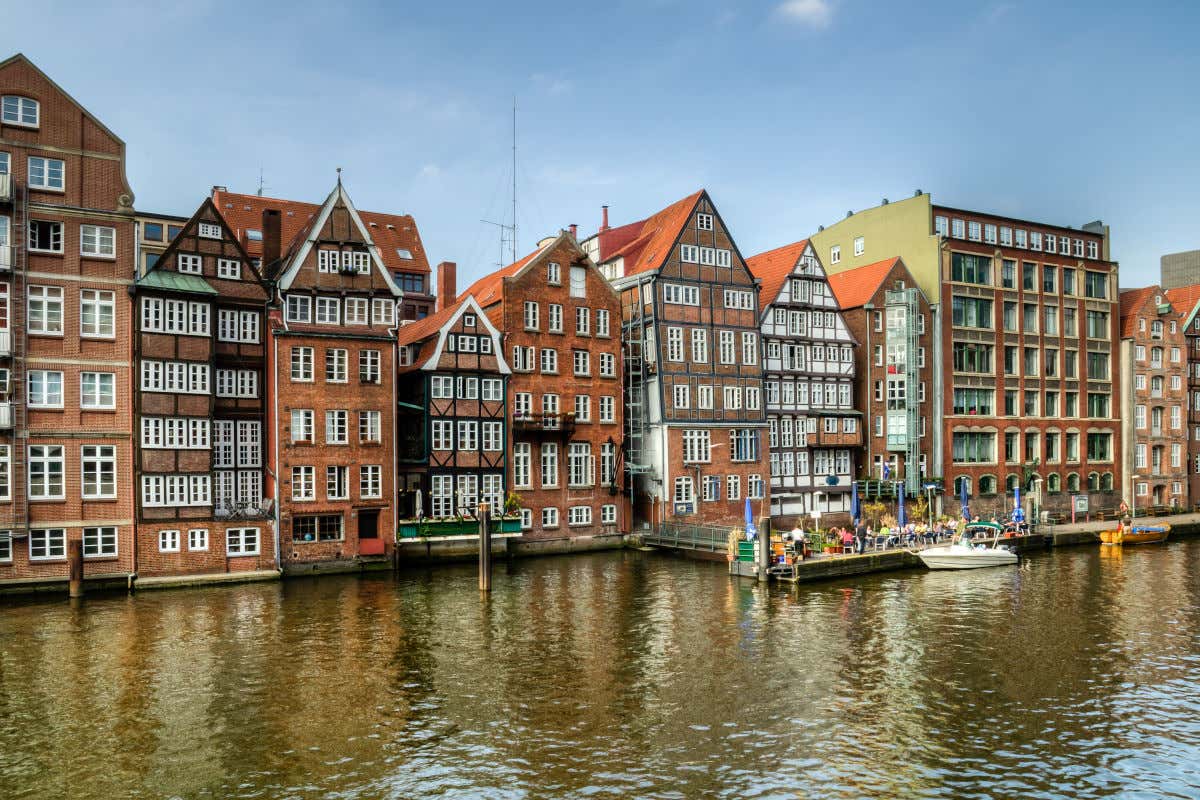 Una hilera de casas antiguas de ladrillo y madera frente a un lago