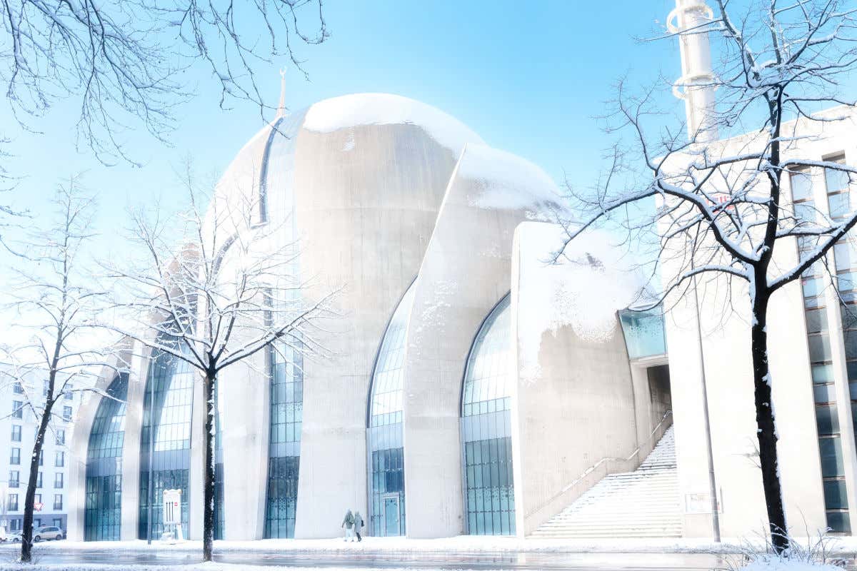 La Mezquita Central de Colonia, una enorme construcción de color blanco y repleta de ventanales, cubierta por un manto de nieve en invierno