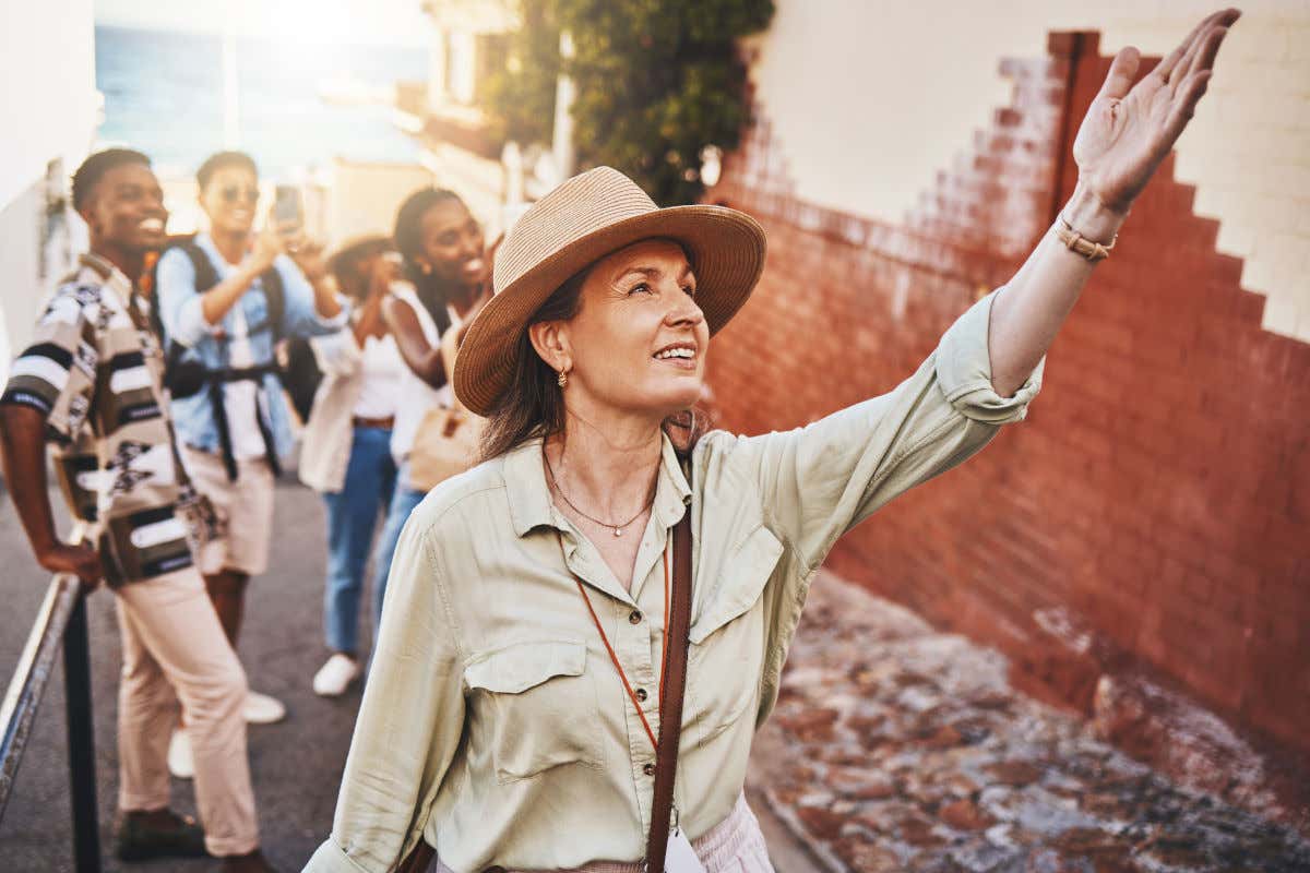 Una mujer que parece ser una guía turística acompañada de un grupo de adolescentes en una calle