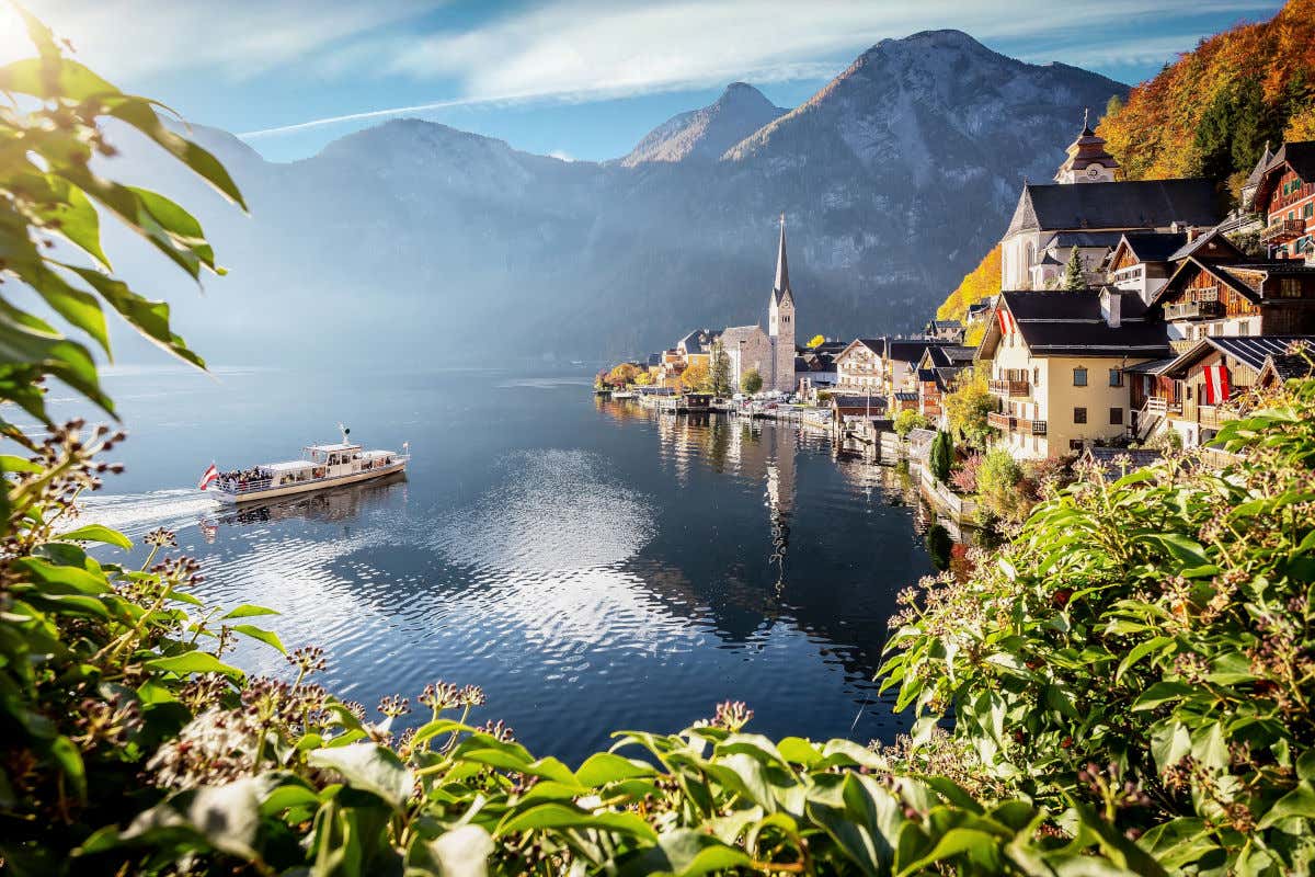 Panorámica de un pueblo de Austria construido junto a un lago y bajo unas montañas nevadas