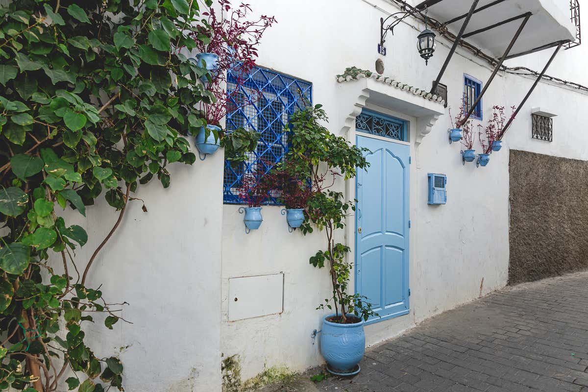 Calle del barrio de la Kasbah de Tánger donde se ve una casa encalada con detalles azules