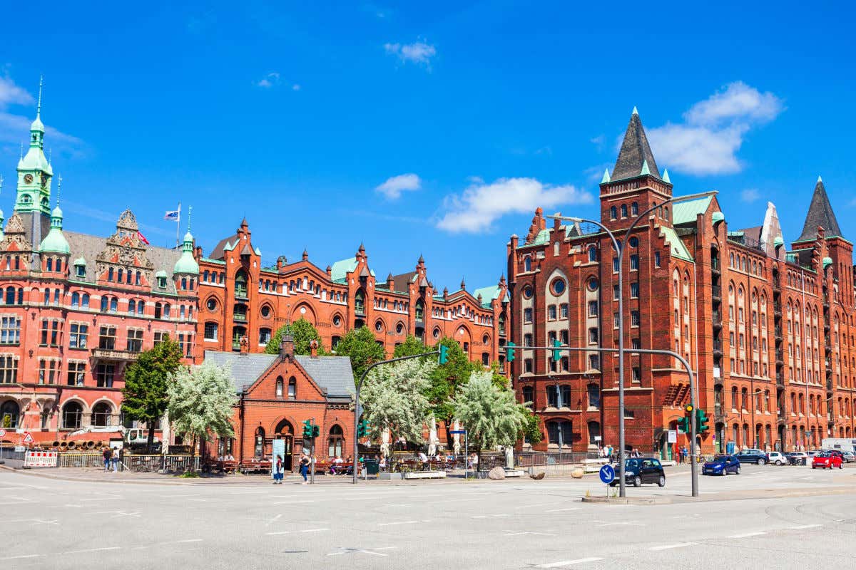 Fachada de ladrillo del Museo Marítimo Internacional de Hamburgo junto a una carretera con varios coches y peatones
