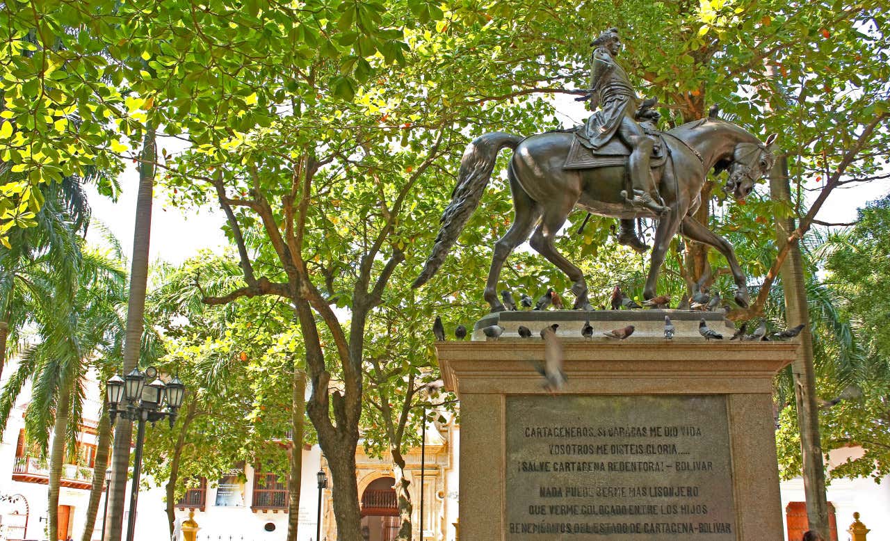Estatua ecuestre de Simón Bolívar en una plaza arbolada de Cartagena de Indias