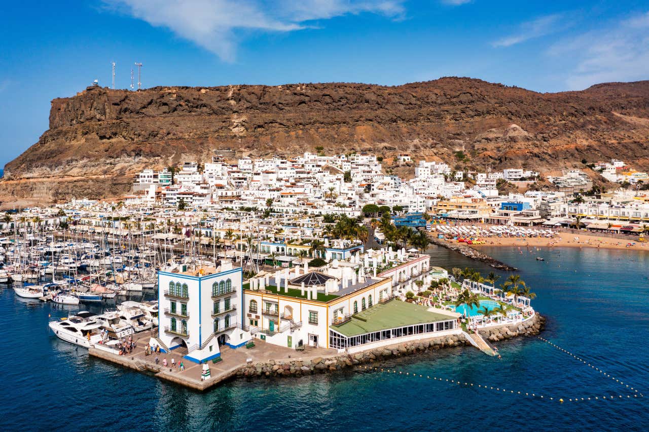 Casas tradicionales junto al puerto y la playa de Mogán, en Gran Canaria, un día soleado
