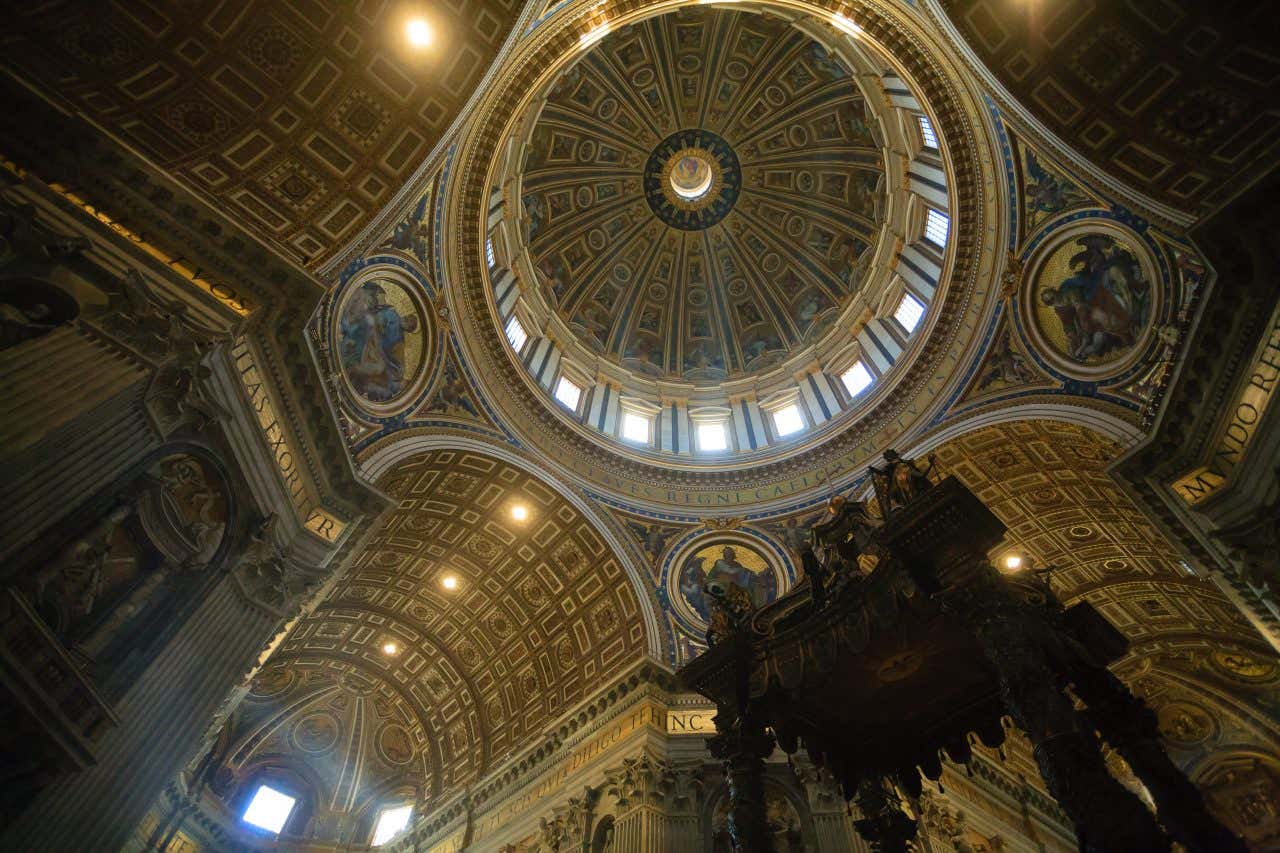 Ecco un alt text ottimizzato per questa magnifica foto degli interni:
Alt Text Proposto:
Versione breve (SEO essenziale):
"Cupola di Michelangelo della Basilica di San Pietro vista dall'interno, Vaticano"
Versione media (bilanciata SEO + descrittiva):
"Vista dal basso della cupola rinascimentale di Michelangelo con cassettoni dorati e finestre, interno della Basilica di San Pietro, Città del Vaticano