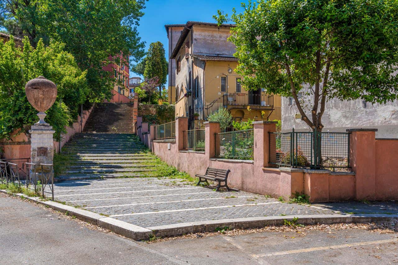 Una scalinata in mezzo ai palazzi intonacati di rosso nel pittoresco quartiere di Garbatella