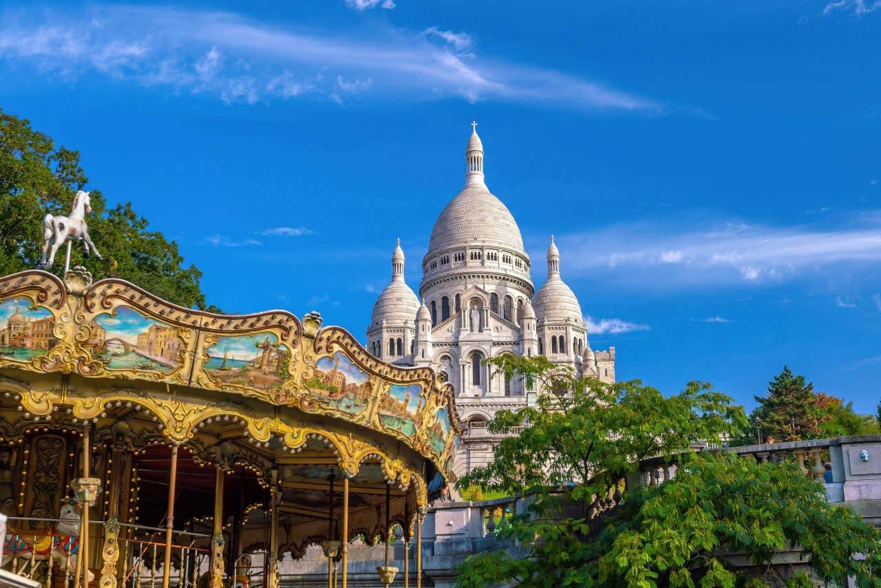 A carousel in Montmartre with the Sacré-Cœur Basilicain the distance.