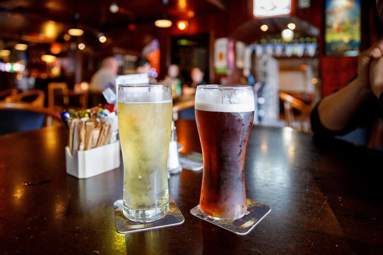Due pinte di birra, una chiara e una scura, sul bancone in legno di un pub di Dublino