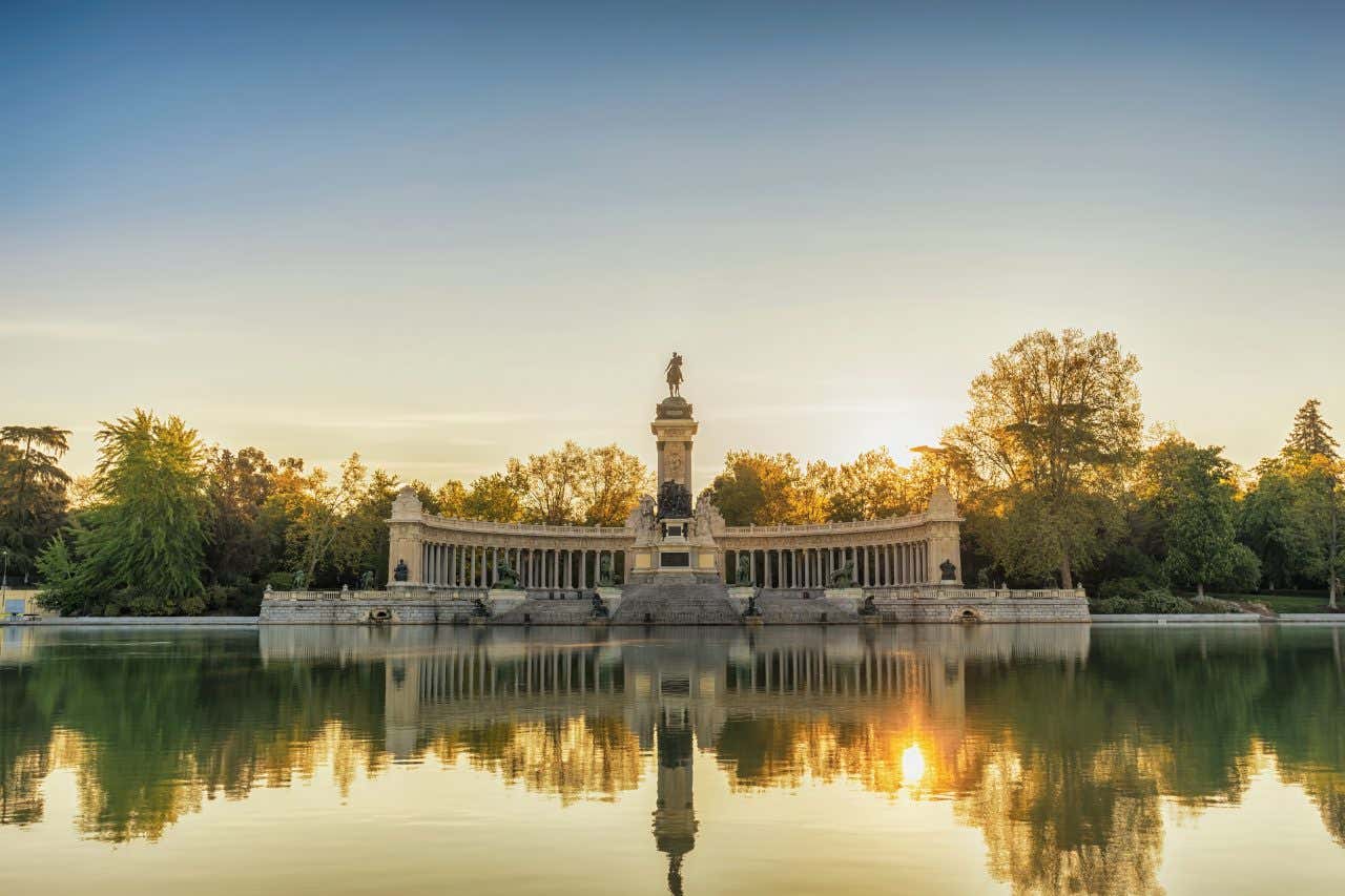 Parc du Retiro dont le monument se reflète dans un étang au coucher du soleil
