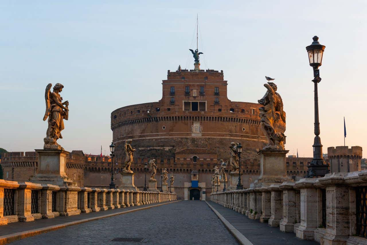 Vista di Castel Sant'Angelo con statue degli angeli del Bernini sul Ponte Sant'Angelo durante il tramonto dorato
