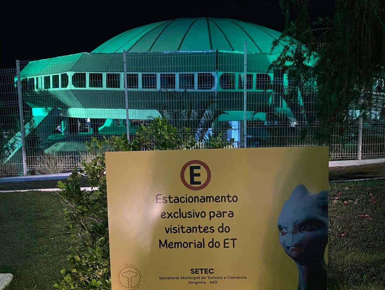 Memorial do ET de Varginha com uma placa à frente "Estacionamento exclusivo para visitantes do Memorial do ET" com a imagem de um alienígena ao lado