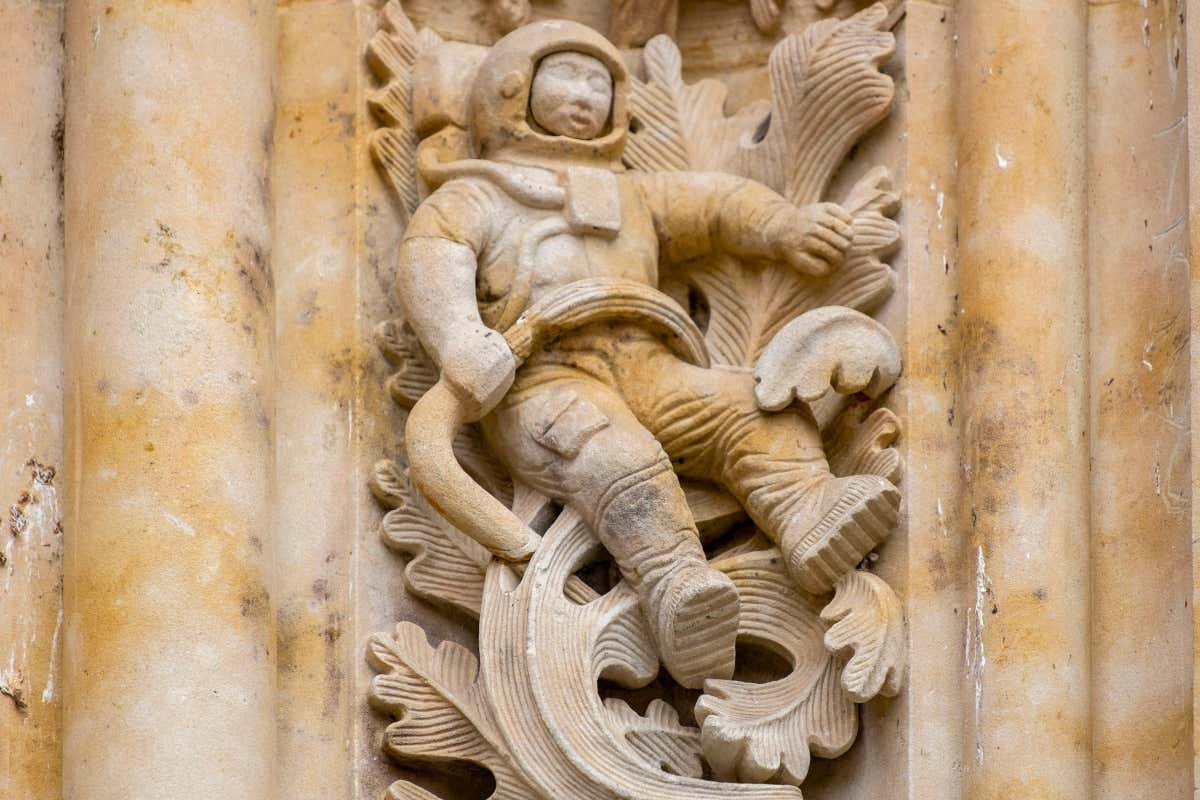 Figura en relieve de un astronauta en la fachada de una catedral